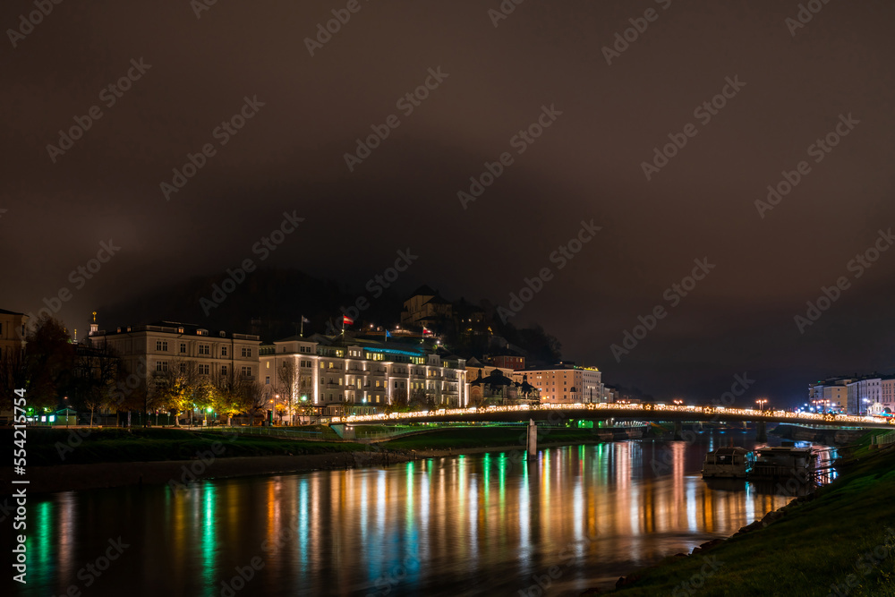 Night view of Salzburg across River Salzach, Austria