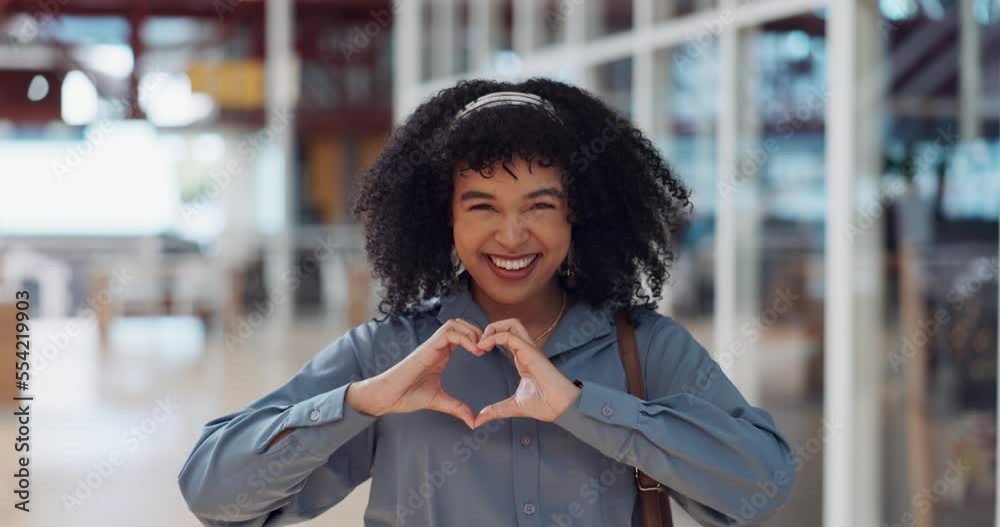 Hands, heart and love with a business black woman making a hand gesture alone in her office at work. Happy, smile and positive with a female employee gesturing a hand sign for romance or affection
