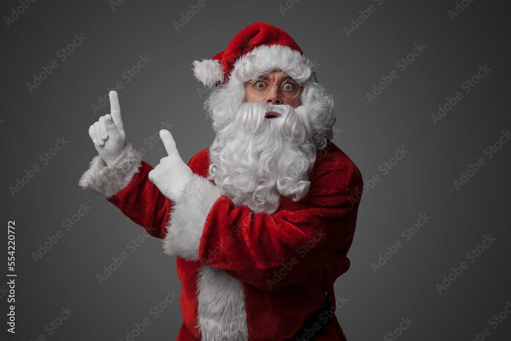 Portrait of old santa claus dressed in red suit pointing up. Portrait of old santa claus dressed in red suit pointing up.