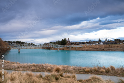 The Maclaren Foot Bridge in late winter with beautiful turquoise color Lake Tekapo. Canterbury, New Zealand South Island.