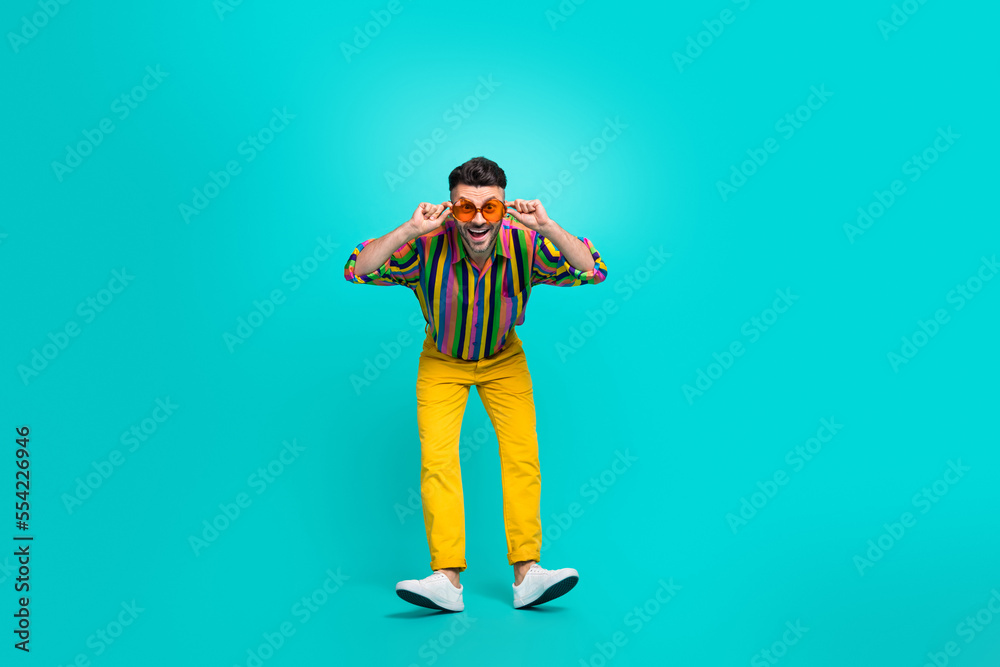Full length size photo of young satisfied glad guy wear summer sunglass touch specs wear retro clothes dancer isolated on aquamarine color background Full length size photo of young satisfied glad guy wear summer sunglass touch specs wear retro clothes dancer isolated on aquamarine color background