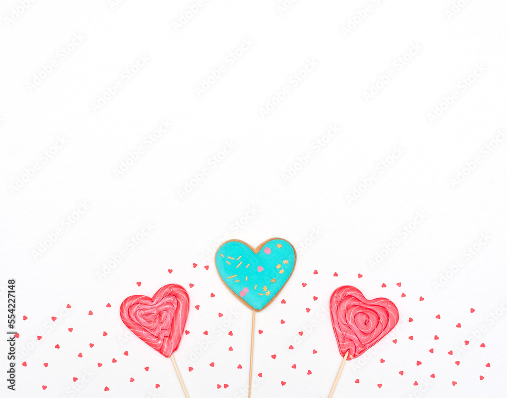 Valentines day card with heart shaped gingerbread and lollipops on white background with red hearts. Love, holiday concept. Flat lay style with copy space