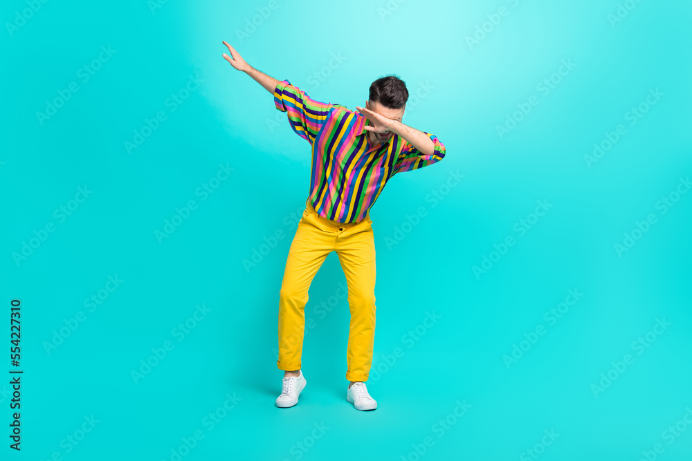 Full body photo of young dancer guy wear vintage striped shirt yellow pants nice sneakers dab sign enjoy trend isolated on cyan color background