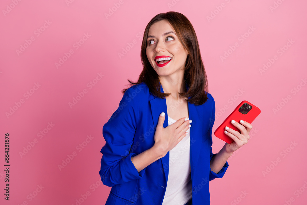 Photo of gorgeous positive lady hold gadget wear trendy clothes hand chest interested look empty space isolated on pink color background Photo of gorgeous positive lady hold gadget wear trendy clothes hand chest interested look empty space isolated on pink color background