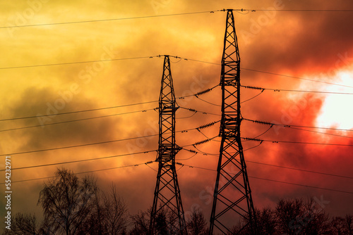 Foto Electric power transmission lines in a dark smoke and fire light.