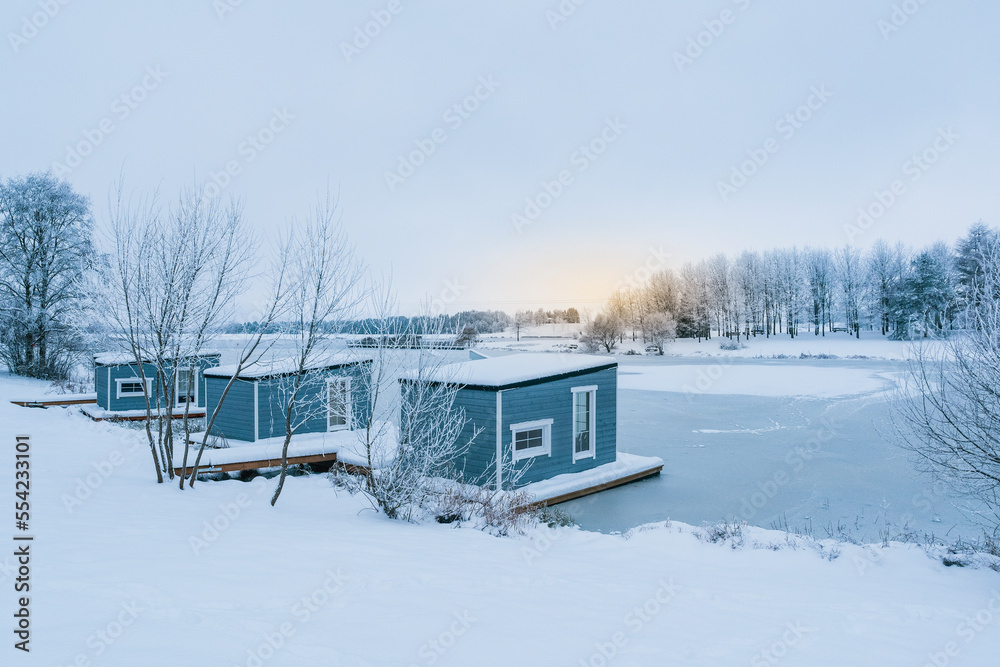 Wooden cabins in the winter scenery with a sunrise