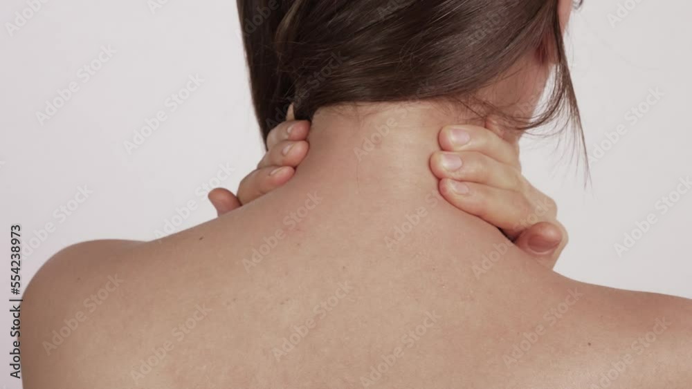 Woman massaging her sore neck Woman massaging her sore neck