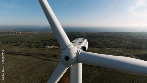 Wind turbine eco farm on summer sea and field landscape. Shot. Renewable energy production for green ecological world.