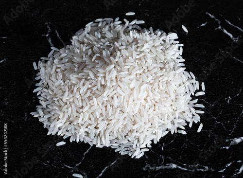 a pile of white rice on a black marble background