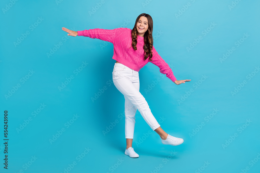 Fototapeta premium Full length photo of charming dreamy lady wear pink sweater walking arms sides isolated blue color background