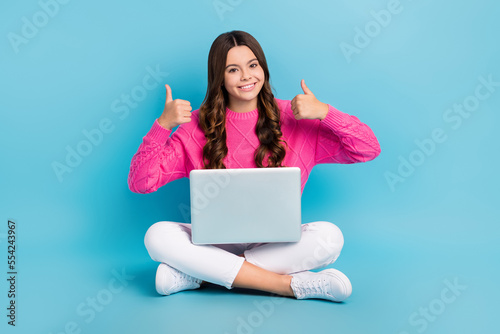 Full length photo of charming confident lady wear pink sweater studying modern device thumbs up isolated blue color background © deagreez