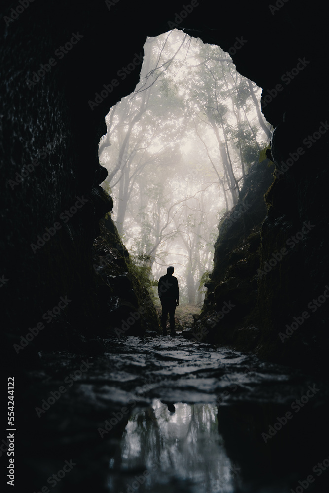a man is standing in a dark cave on madeira