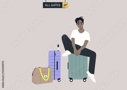 A passenger waiting for departure in the airport lounge with their cabin luggage, all gates sign hanging from the ceiling