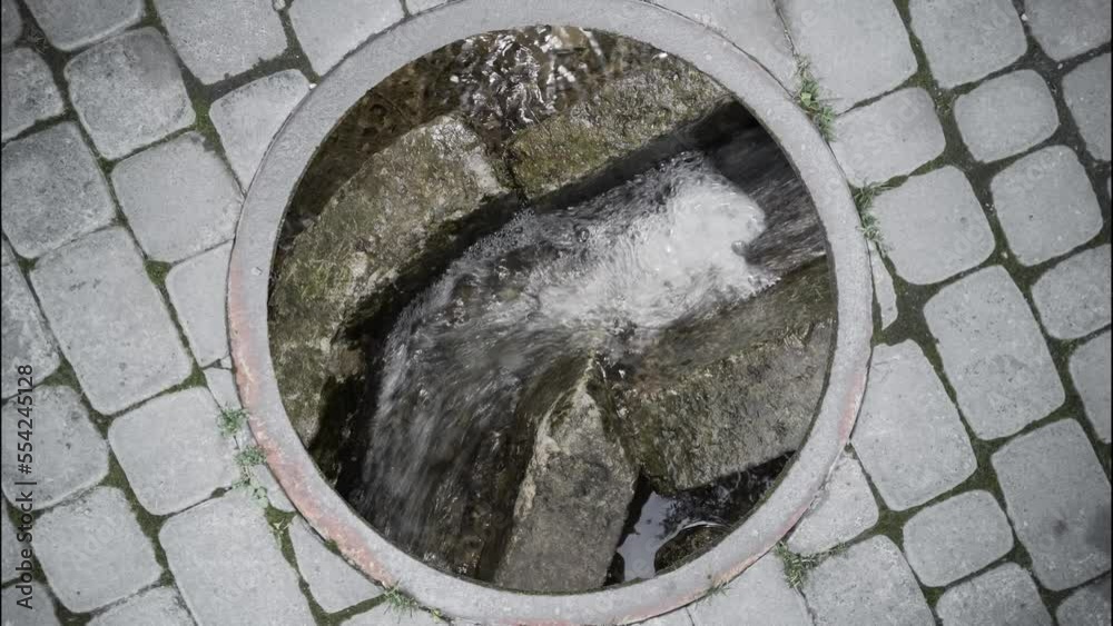 Wastewater Flows In Drain At The Bottom Of An Open Sewer Manhole On The wastewater-flows-in-drain-at-the-bottom-of-an-open-sewer-manhole-on-the