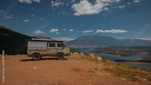 Adventure oldtimer van or camper, campervan on high plain with good view panorama of city Kukes in albania on a summer day. Albanian roadtrip with vintage campervan
