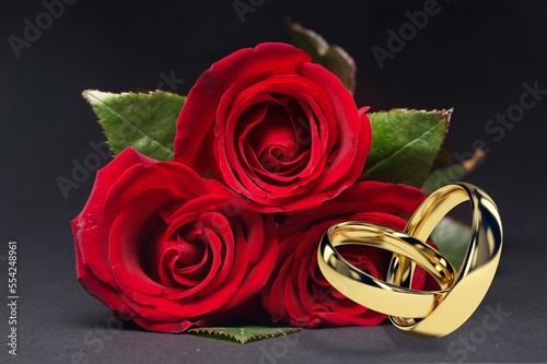 Beautiful gold wedding rings and fresh beauty flowers