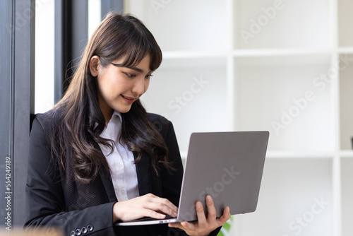 Portrait of a businesswoman holding a laptop working in the office.