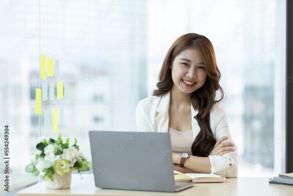 Portrait of a charming Asian business woman working on a laptop in the office. Portrait of a charming Asian business woman working on a laptop in the office.