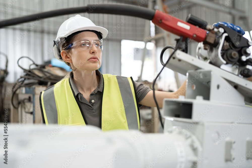 Caucasian technician engineer woman checking machine arm robot at factory Caucasian technician engineer woman checking machine arm robot at factory