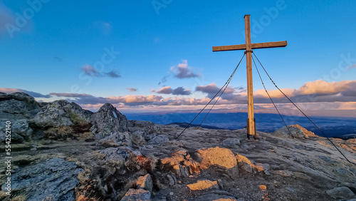 Scenic evening view during sunset on summit cross of mountain peak Zingerle Kreuz, Saualpe, Lavanttal Alps, Carinthia, Austria, Europe. Hiking trail Wolfsberg. Sky in soft colors creating calm vibes photo