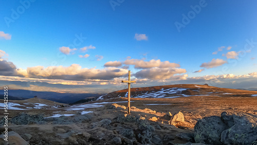 Scenic evening view during sunset on summit cross of mountain peak Zingerle Kreuz, Saualpe, Lavanttal Alps, Carinthia, Austria, Europe. Hiking trail Wolfsberg. Sky in soft colors creating calm vibes