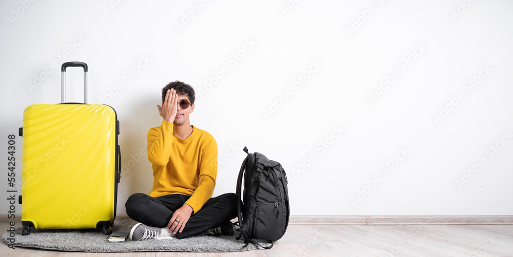 Smiling young man traveler, with eye, closed by hand, covering part of her face, over white background, with blank copy space area for slogan or text message. Smiling young man traveler, with eye, closed by hand, covering part of her face, over white background, with blank copy space area for slogan or text message.