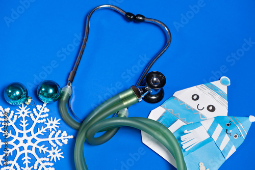 Christmas and New Year Medicine - Stethoscope, Snowmen and Snowflakes on a Blue Background, Top View photo