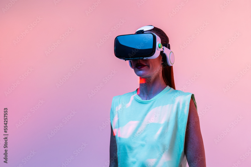 Woman playing VR game in neon light Woman playing VR game in neon light