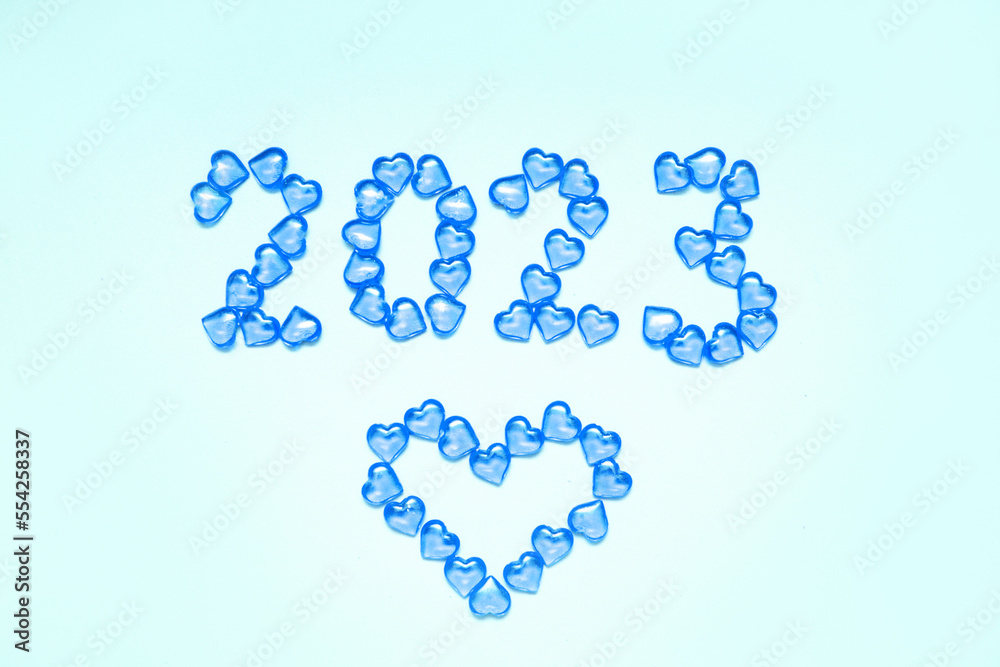 New Year 2023 inscription from glass hearts on a blue background. Pantone color 2023. Idea and creativity. Valentine's Day. Christmas with loved ones. Horizontally, banner. High quality photo New Year 2023 inscription from glass hearts on a blue background. Pantone color 2023. Idea and creativity. Valentine's Day. Christmas with loved ones. Horizontally, banner. High quality photo