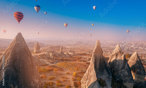 Cave in big stone, hot air balloons fly over deep canyons, valleys Cappadocia Goreme National Park, Banner Turkey Travel