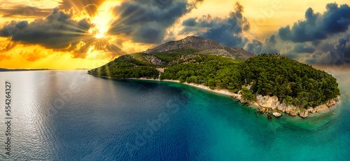 Amazing sunset seascape, beauty of nature. Scenic view of the sea, rocky seacoast and sandy beach, golden colored sky and sun, outdoor travel background, Croatia