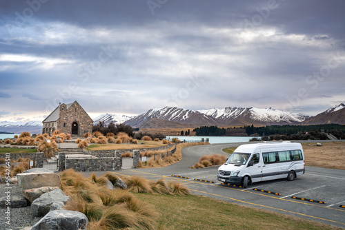 Sunrise view of the Lake Tekapo in late winter with snow capped mountain at the background, New Zealand South Island. Best way to travel the country via road trip with camper van.  photo