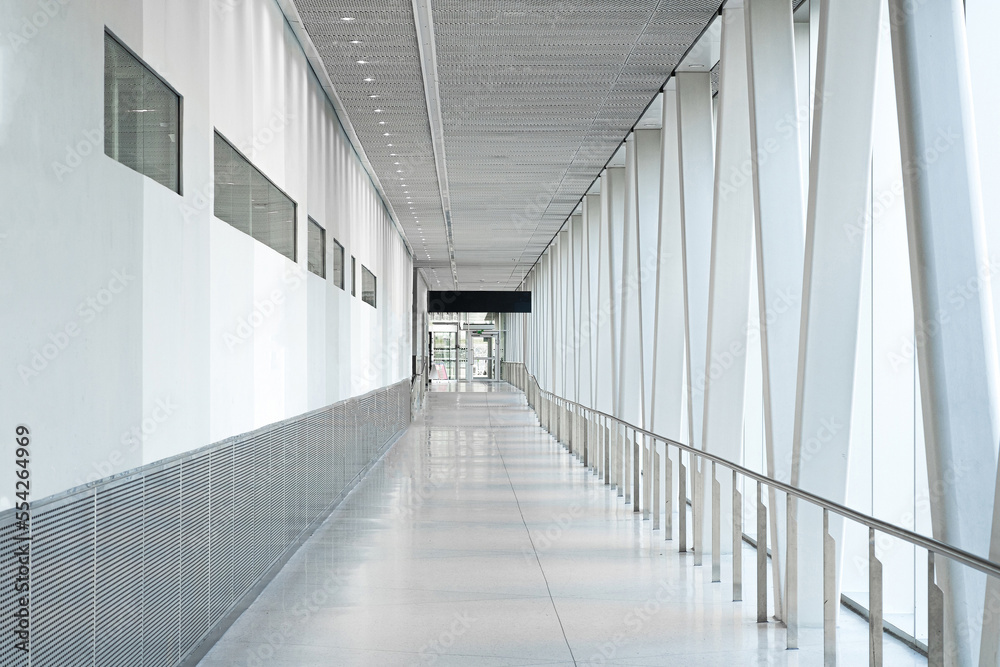 Fototapeta premium A corridor with white wall, glass facade and truss structure