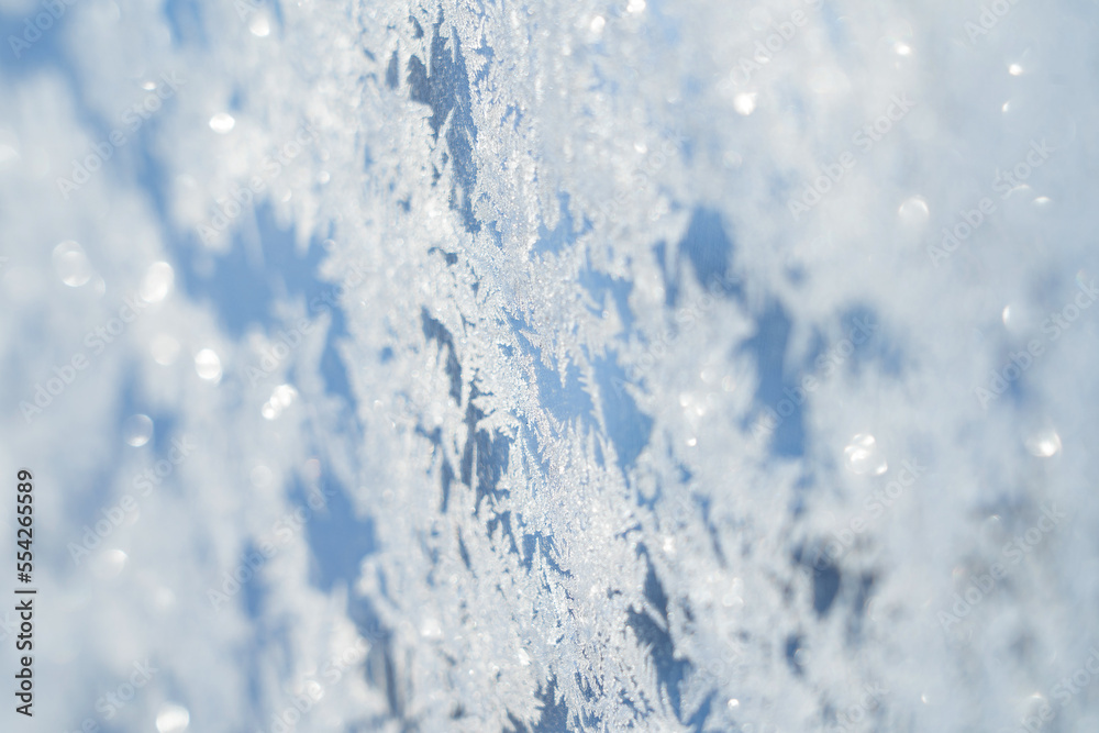 Obraz premium snow frost in the form of natural patterns on the window pane against the background of the morning sky