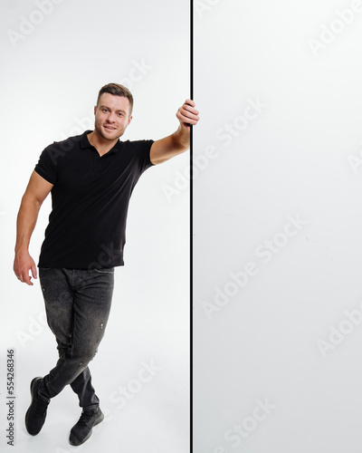 Young man with blank billboard. Happy smiling young man showing blank signboard, isolated over white background.