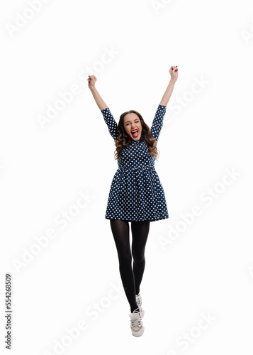 Happy woman standing with her hands up, isolated on white background. A full length shot of a smiling woman