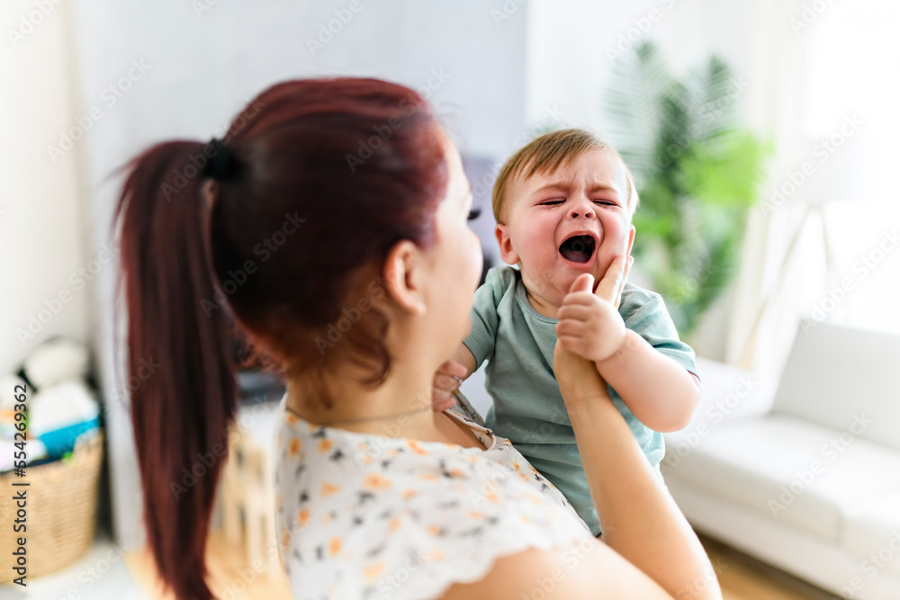 mother holding child baby on the living room. The baby is sick having some cough mother holding child baby on the living room. The baby is sick having some cough