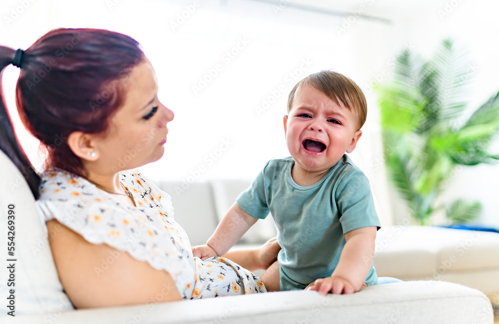mother holding child baby on the living room. The baby is sick having some cough mother holding child baby on the living room. The baby is sick having some cough