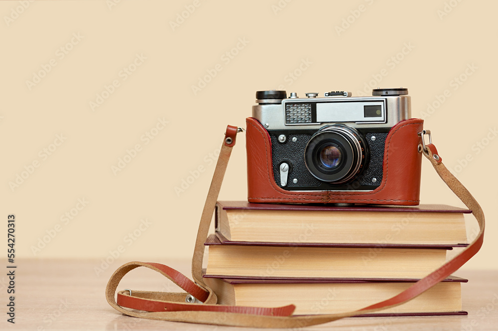 Vintage camera on a stack of books. Photography concept.