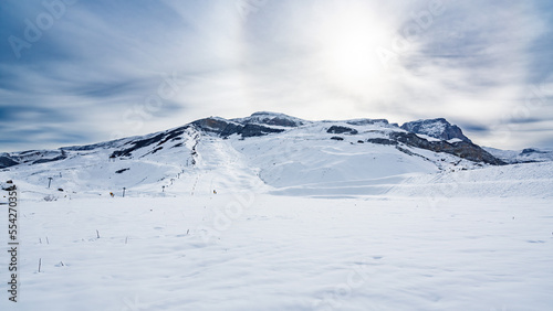 Snow capped mountains with ski tracks photo