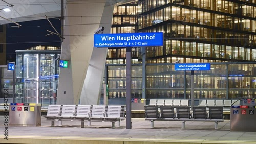 Vienna central station Hauptbahnhof sign on train platform, hyperlapse at night. Main railway transportation hub in Wien, Austria.