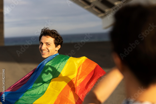 Gay couple having fun outside. Happy couple making a heart sign with their hands.