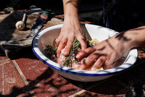 un cuoco prepara un intingolo con della carne e varie spezie in contesto esterno  photo