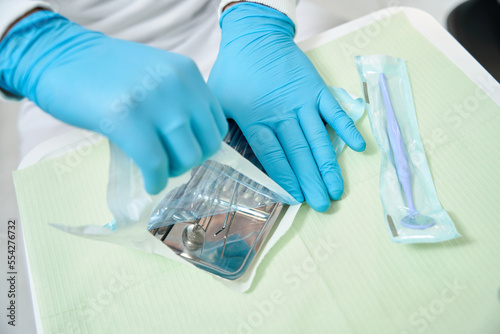 Dentist preparing for examination of patient teeth photo