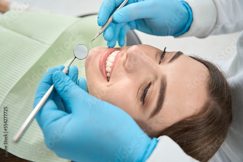 Doctor preparing for examination oral cavity of young woman