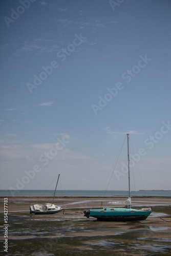 Old boats and sailing ships lying in the mud at low tide in the Atlantic Ocean near the Ile de R  