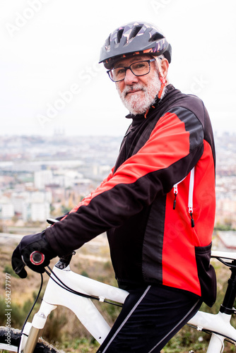 portrait of older cyclist with bike in sports clothes