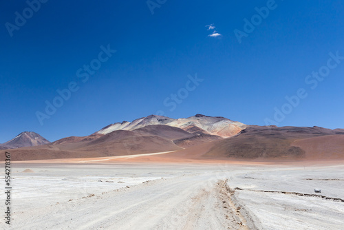 Dusty dirt road with colourful mountains in the background  Eduardo Avaroa Andean Fauna National Reserve  Bolivia