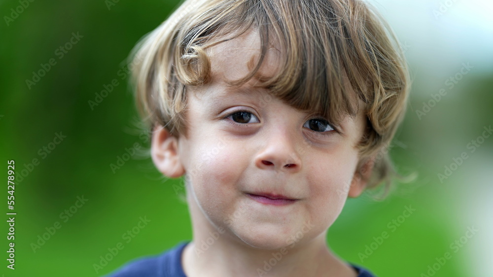 Adorable child portrait smiling at camera little boy face closeup smiles outside at park Adorable child portrait smiling at camera little boy face closeup smiles outside at park