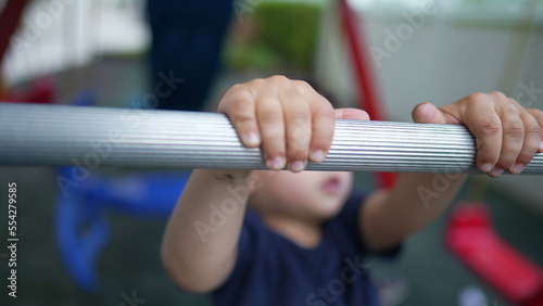 Child holding into monkey bar at playground kid falling down kid falls down to ground